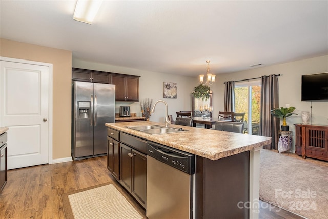 kitchen featuring a center island with sink, sink, light hardwood / wood-style flooring, dark brown cabinets, and stainless steel appliances