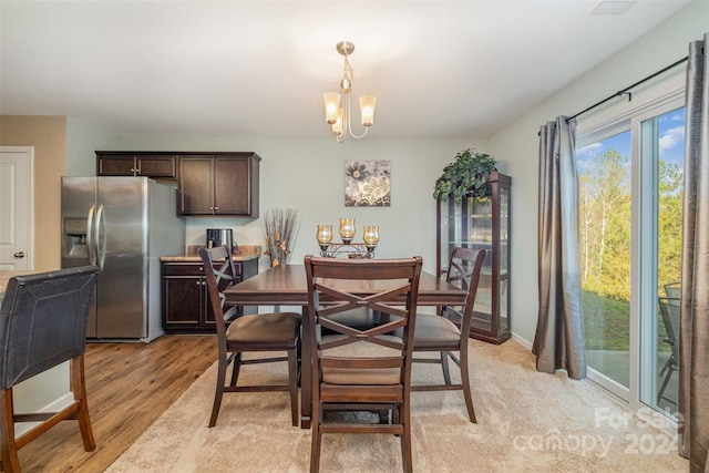 dining room with light hardwood / wood-style floors and a notable chandelier