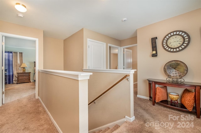 hallway featuring light colored carpet