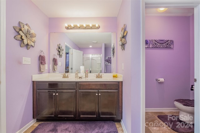 bathroom featuring tile patterned flooring, vanity, toilet, and walk in shower