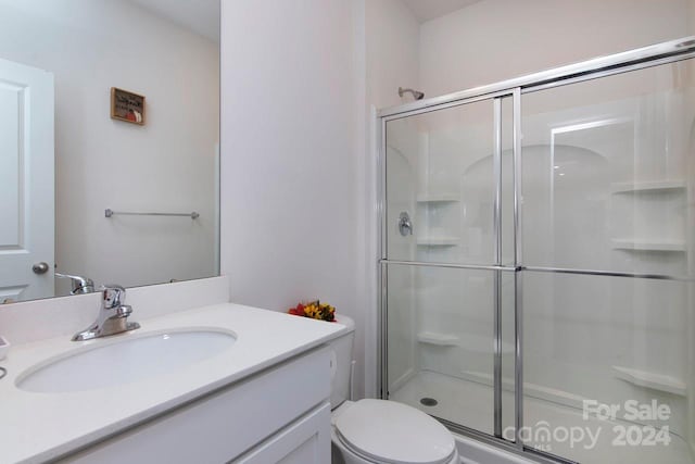 bathroom featuring vanity, toilet, and walk in shower