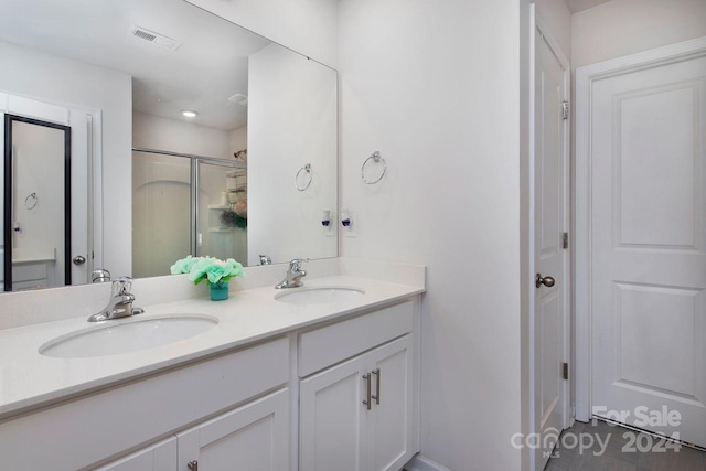 bathroom with a shower with door and vanity