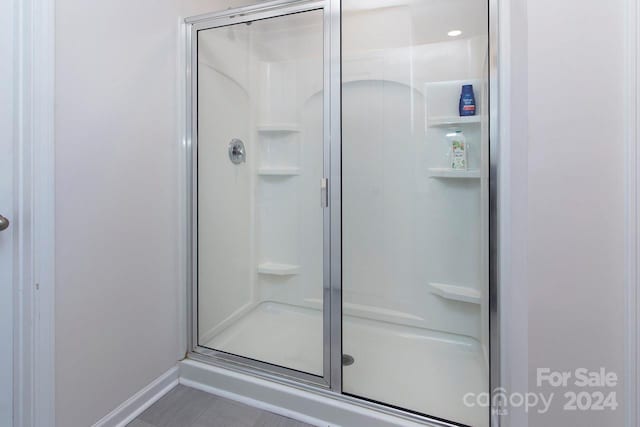 bathroom with tile patterned flooring and a shower with shower door