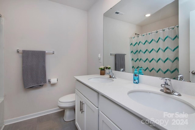 bathroom with a shower with shower curtain, vanity, and toilet