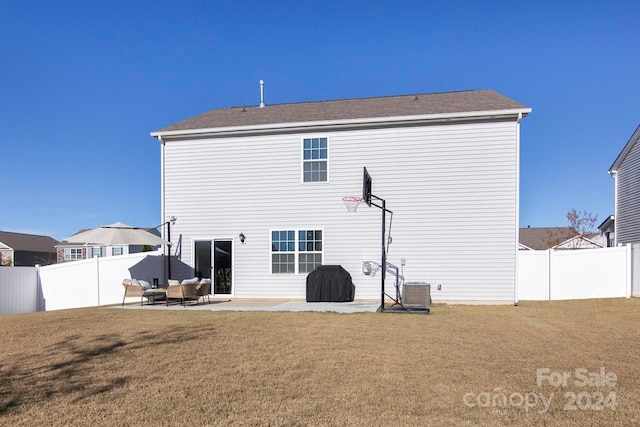 rear view of property with a lawn, central AC unit, and a patio