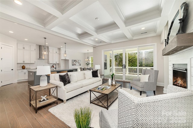 living room featuring a lit fireplace, dark wood-style flooring, coffered ceiling, and beam ceiling