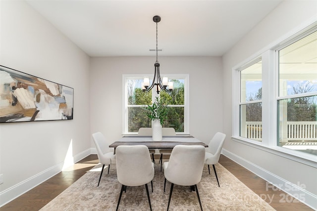 dining room with an inviting chandelier, baseboards, and dark wood-type flooring