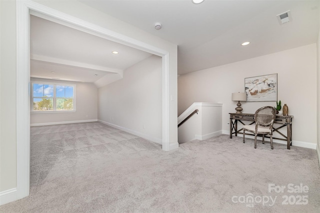 interior space featuring carpet, baseboards, visible vents, and an upstairs landing