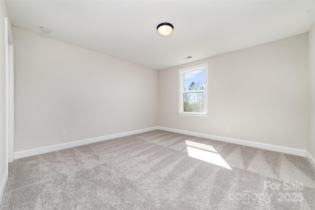 carpeted empty room with visible vents and baseboards