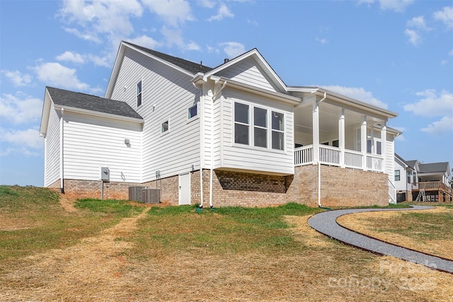 exterior space featuring covered porch, central AC, and a yard