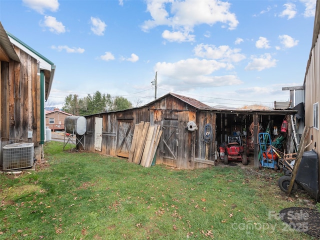 view of outbuilding with central AC and a lawn