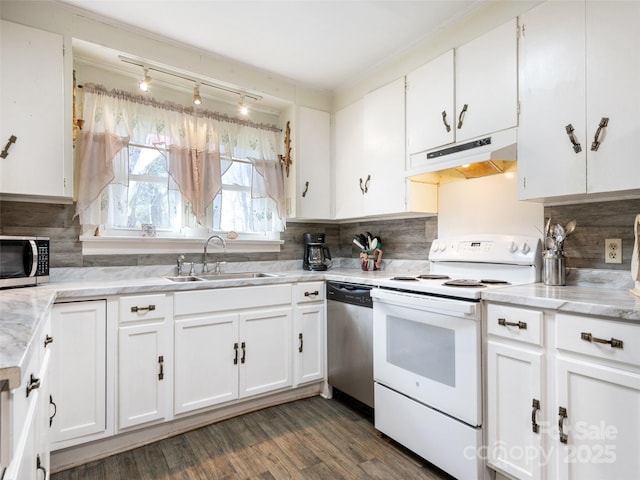 kitchen with sink, backsplash, white cabinets, dark hardwood / wood-style flooring, and stainless steel appliances