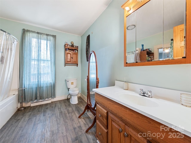 full bathroom featuring wood-type flooring, vanity, a baseboard heating unit, toilet, and shower / bathtub combination with curtain