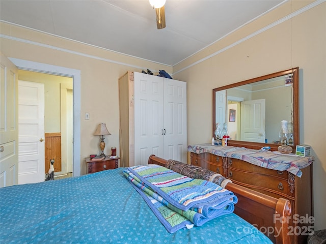 bedroom featuring ceiling fan, ornamental molding, and a closet