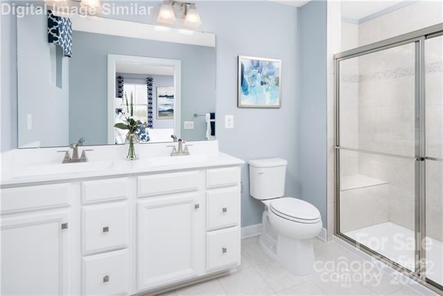 bathroom with walk in shower, vanity, and toilet