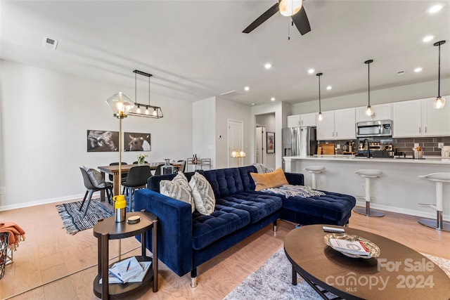 living room with ceiling fan and light hardwood / wood-style floors