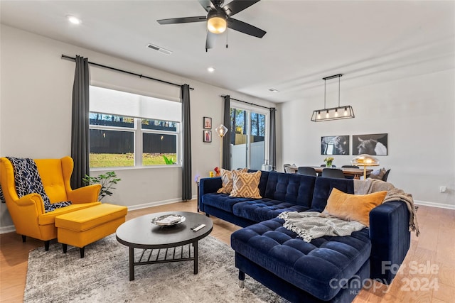 living room with ceiling fan and light hardwood / wood-style flooring