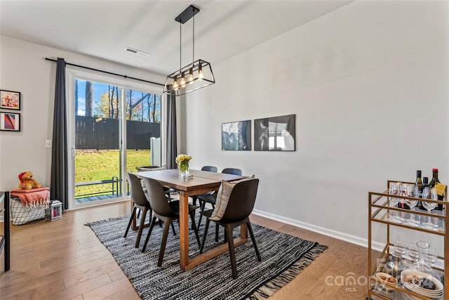 dining room with a notable chandelier and wood-type flooring