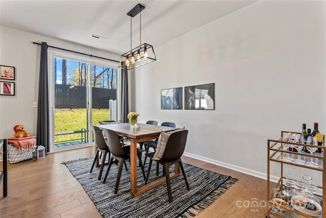 9232 Widden Way, Charlotte, NC 28269 - dining space with a chandelier, wood finished floors, and baseboards