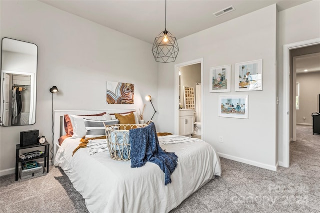 carpeted bedroom featuring ensuite bath