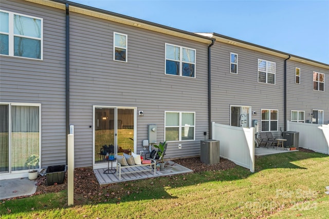 rear view of property with a lawn, a patio area, and central AC