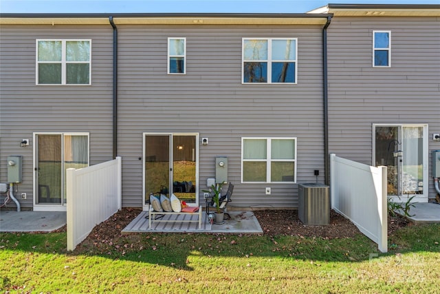 rear view of house featuring a patio, cooling unit, and a lawn