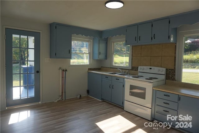 kitchen with sink, light hardwood / wood-style flooring, decorative backsplash, gray cabinets, and white electric range oven