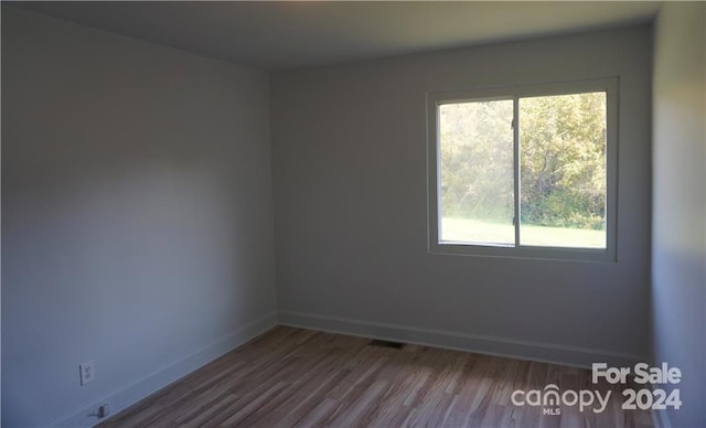 unfurnished room with hardwood / wood-style floors