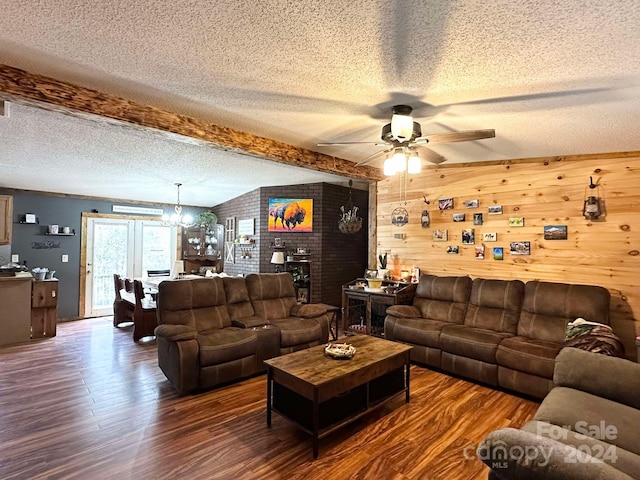 living room featuring dark hardwood / wood-style flooring, a textured ceiling, lofted ceiling with beams, a fireplace, and wood walls