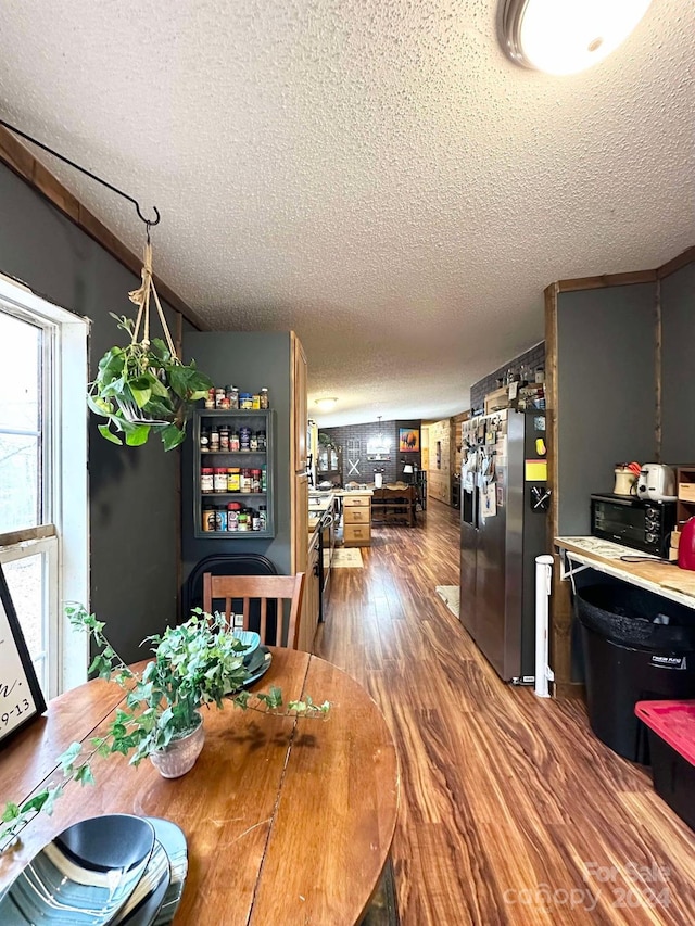 dining space featuring a textured ceiling and hardwood / wood-style flooring