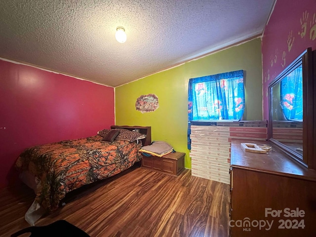 bedroom featuring a textured ceiling and dark wood-type flooring