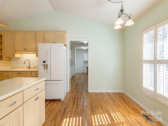 kitchen with light brown cabinets, white fridge with ice dispenser, light hardwood / wood-style flooring, a textured ceiling, and decorative light fixtures