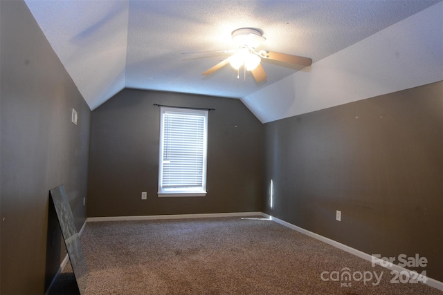 additional living space featuring a textured ceiling, ceiling fan, carpet, and lofted ceiling