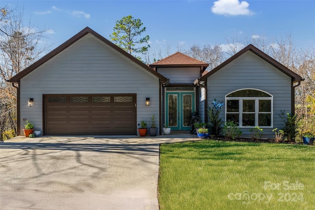 view of front of house featuring french doors, a front lawn, and a garage