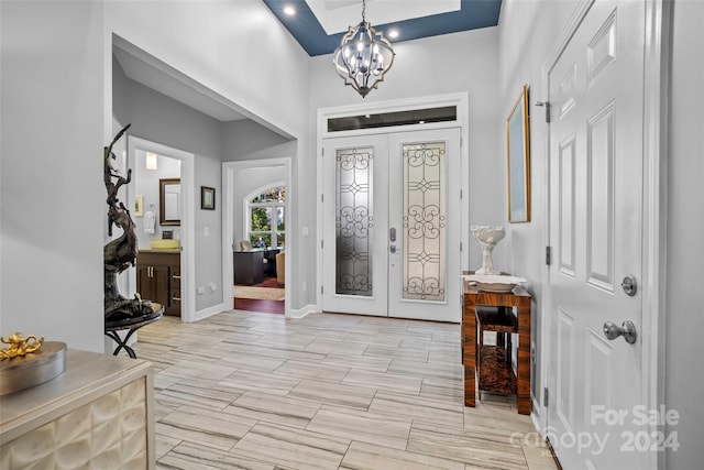 entryway with french doors and a notable chandelier