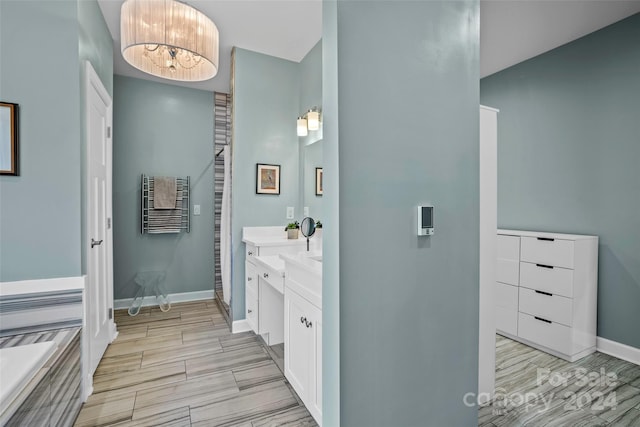 bathroom with vanity, an inviting chandelier, wood-type flooring, and heating unit