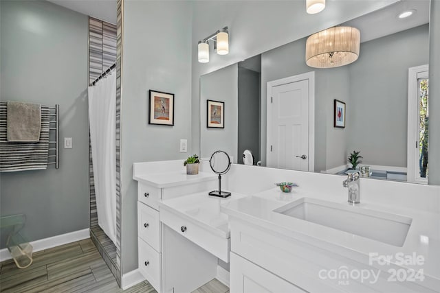 bathroom featuring hardwood / wood-style floors, vanity, and walk in shower