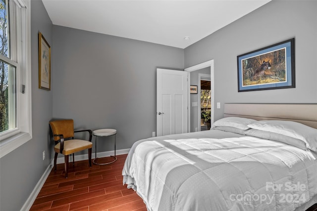 bedroom with dark hardwood / wood-style flooring