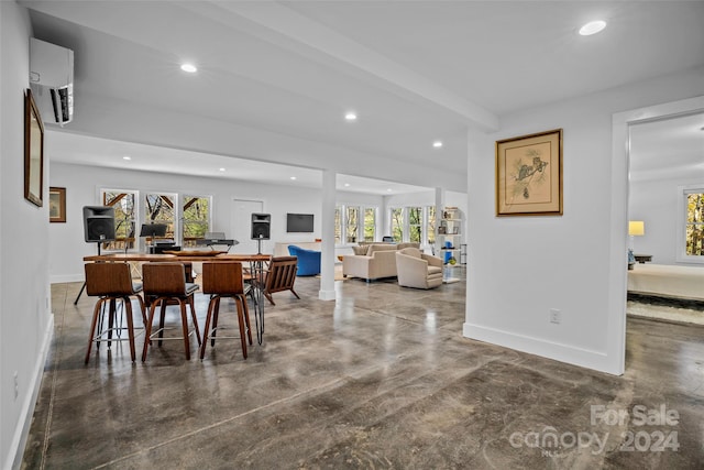 dining space featuring a healthy amount of sunlight, an AC wall unit, and beam ceiling