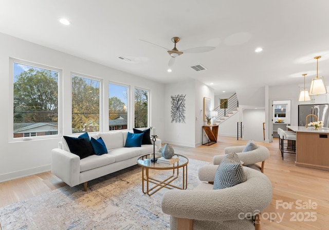 living room featuring ceiling fan and light wood-type flooring