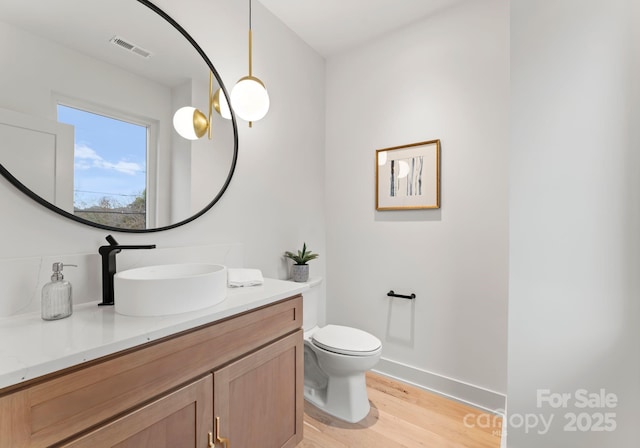 bathroom with vanity, wood-type flooring, and toilet