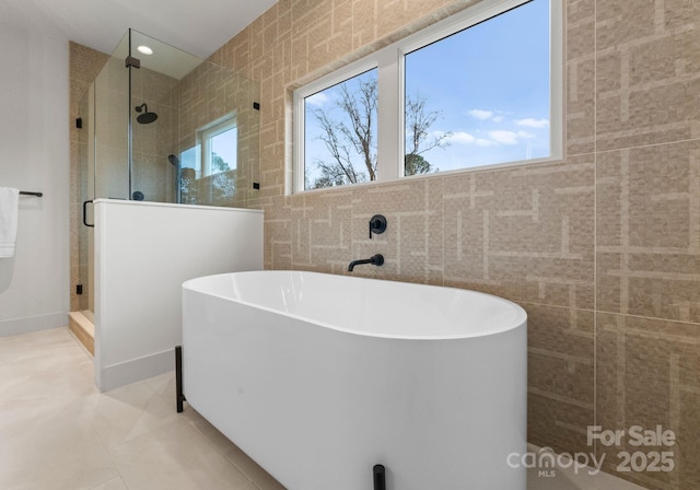 bathroom featuring tile patterned flooring, independent shower and bath, and a healthy amount of sunlight