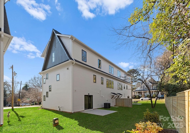 rear view of property featuring a lawn, a patio area, and cooling unit