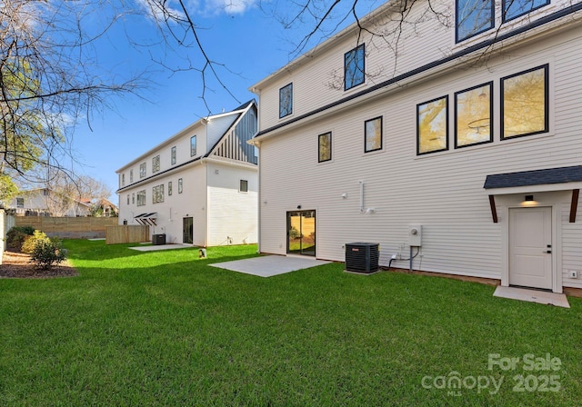 back of house featuring a lawn, a patio area, and central AC