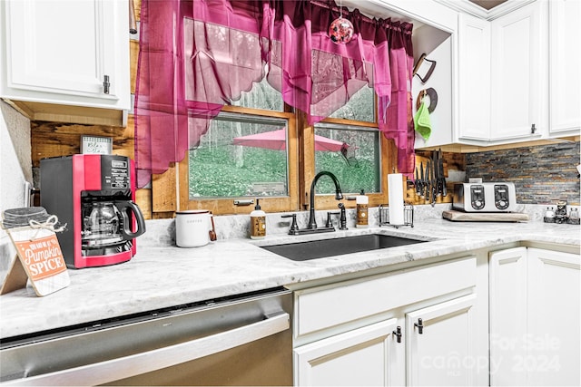 kitchen with dishwasher, backsplash, sink, light stone counters, and white cabinetry