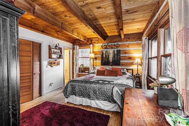 bedroom with beamed ceiling, light hardwood / wood-style floors, a closet, and wood ceiling