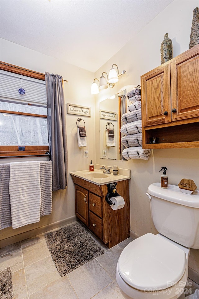 bathroom with tile patterned flooring, vanity, and toilet