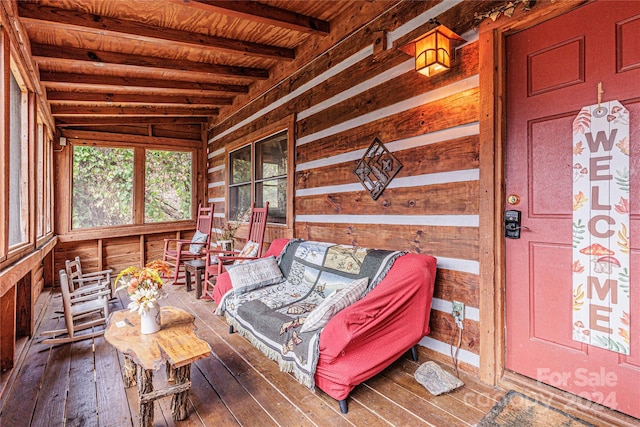 sunroom / solarium featuring lofted ceiling with beams