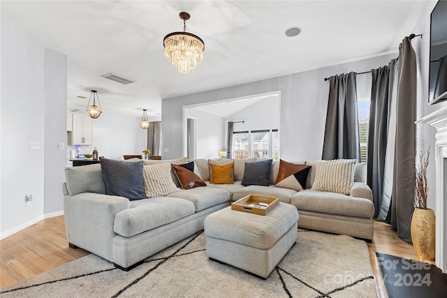 living room featuring light hardwood / wood-style flooring and a notable chandelier