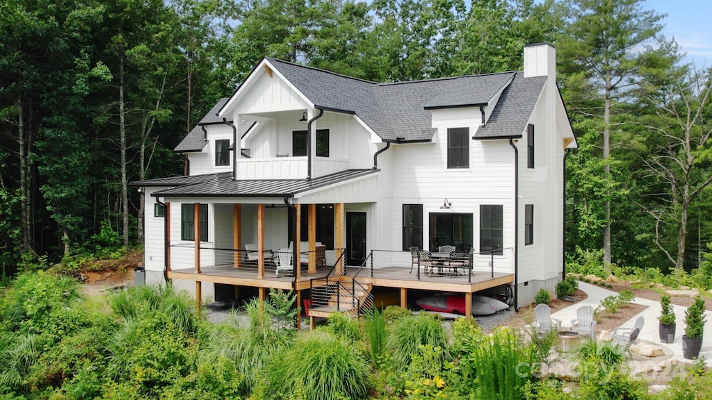 rear view of property featuring a balcony and a deck